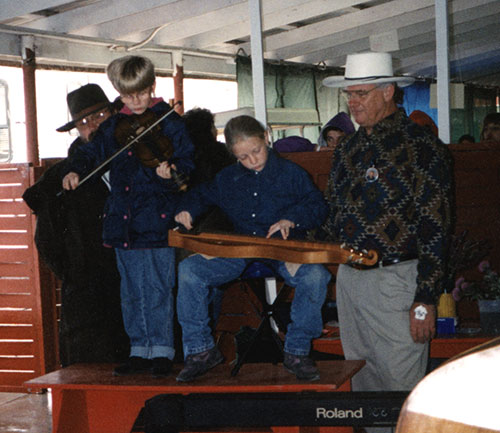 Erin and Amber performing for Acoustic Kids at the Walnut Valley Festival circa 1997. 
Also pictured is Dennis Moran, emcee for many mountain dulcimer competitions, who was assisting that day.