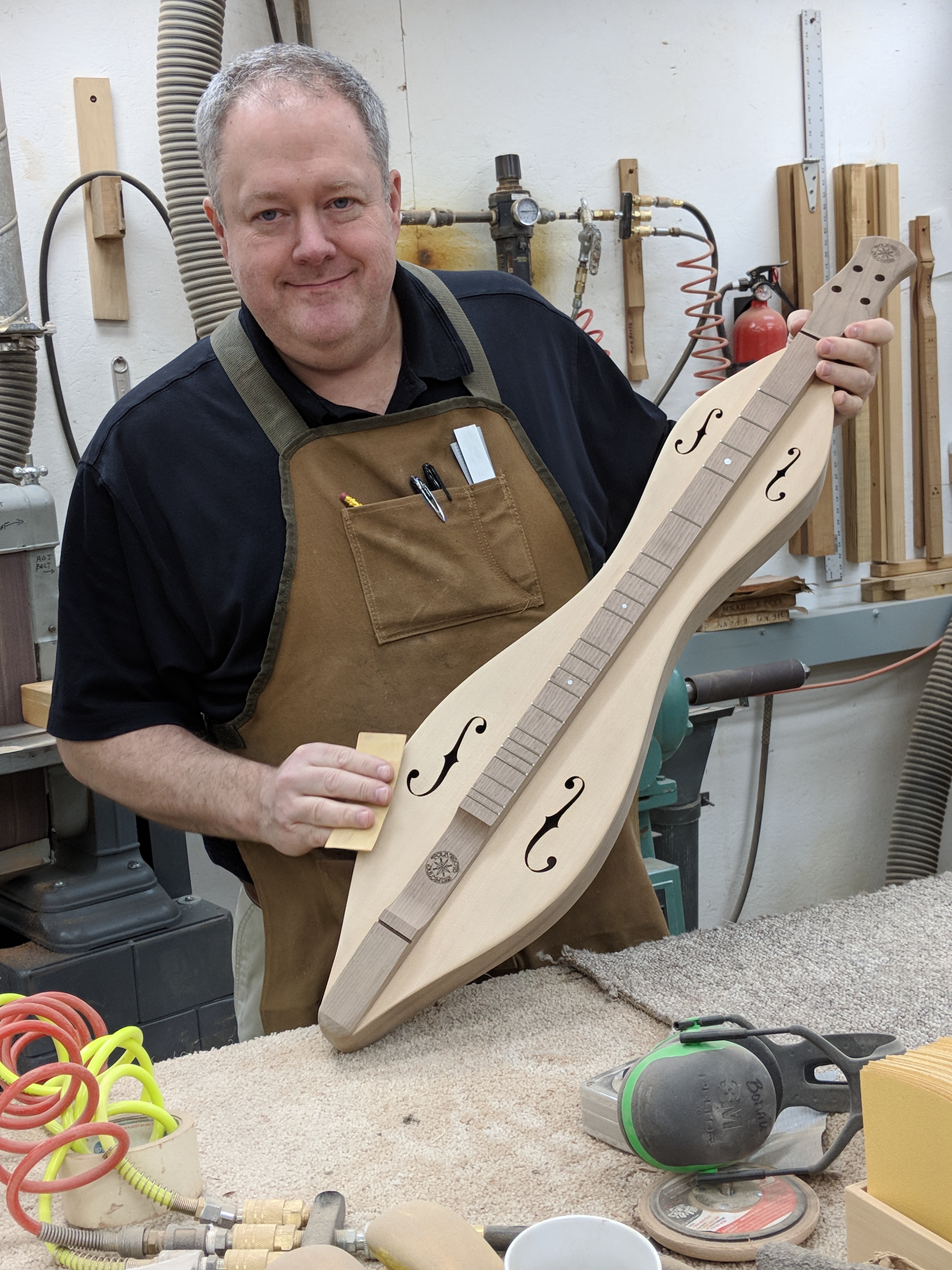 Richard Ash is putting the finishing touches on a FolkRoots mountain dulcimer. Hand sanding is a big part of making an instrument feel good to the player's touch.